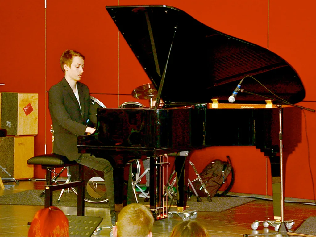Ein Pianist spielt am Flügel auf der Bühne.